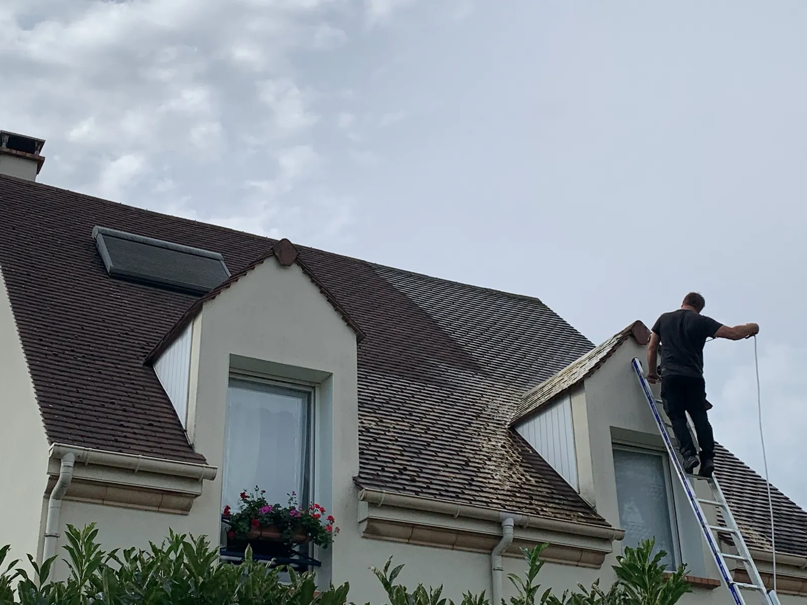 Nettoyage d'une toiture en tuiles depuis une échelle — M. Simonard, couvreur en Seine-et-Marne