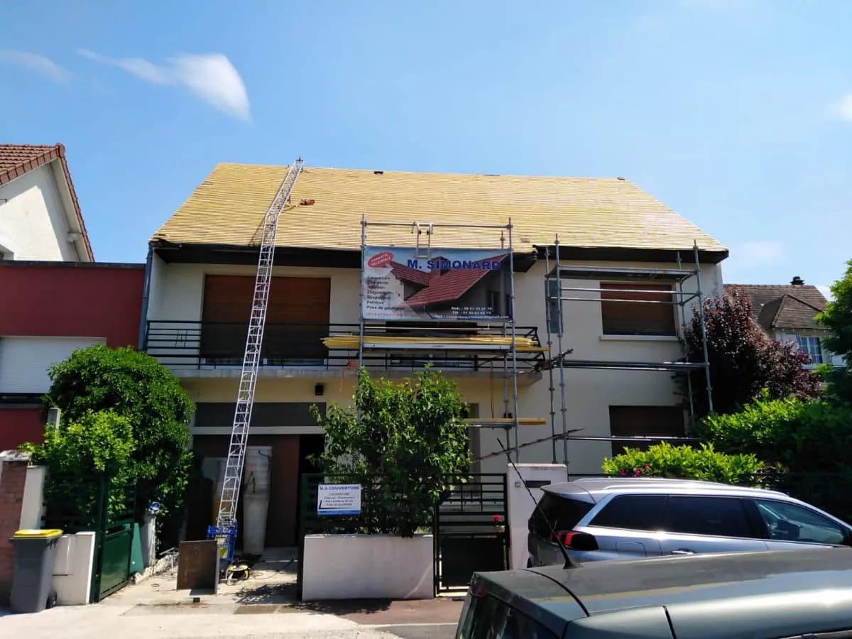 Chantier de toiture sous échafaudage avec la banderole Simonard Artisan Couvreur — Seine-et-Marne